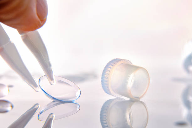 istock Hand with tweezers catching contact lenses on glass table 1181156849