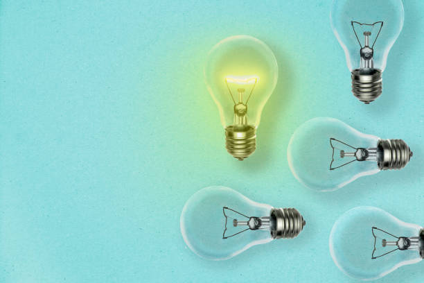 istock Idea concept background with many light bulbs dropping shadow on a blue paper sheet and copy space for your text 1181157935