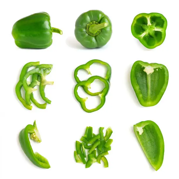 Photo of Set of fresh whole and sliced green bell pepper isolated on white background. Top view