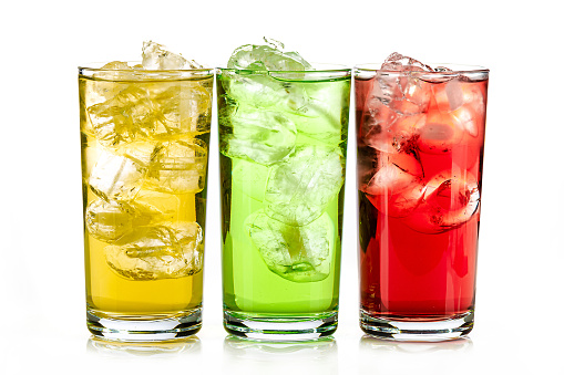 yellow, green and red drink with ice cubes on white background, isolated