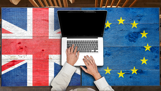 European and UK flagged wooden Table with laptop