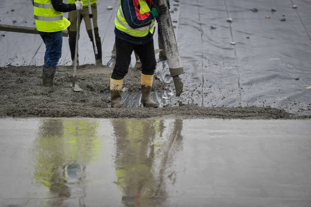 szczegóły z zespołem pracowników wylewających beton na plac budowy. - contracting construction built structure concrete zdjęcia i obrazy z banku zdjęć