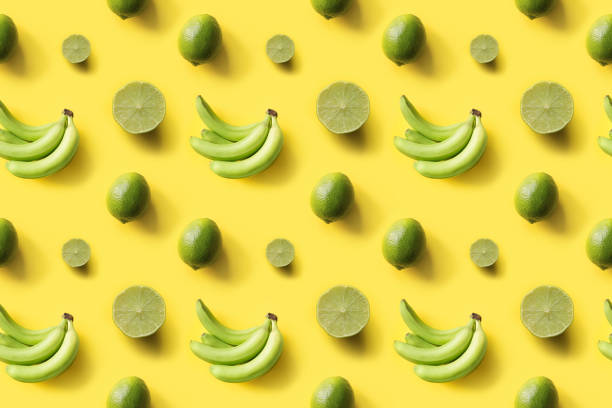 istock Seamless tropical pattern bananas, limes on yellow background. Creative food concept. Flat lay. Top view. 1181163137