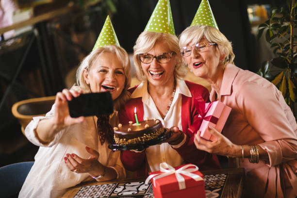 istock Senior ladies taking selfie while celebrating birthday in cafe 1181169525