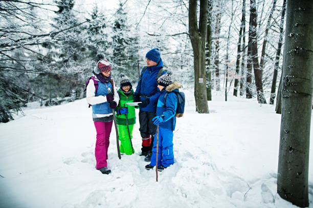 istock Father with kids hiking in winter forest 1181171042