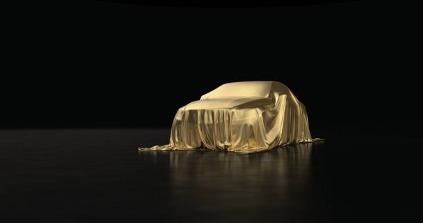 The luxury car is covered with a gold cloth on a black background.