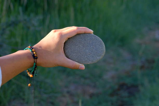 istock Female hand holding a stone with room for placing text 1181171738