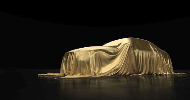 istock The luxury car is covered with a gold cloth on a black background. 1181171740
