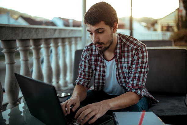 istock Young man sitting in coffee shop and using laptop 1181171831