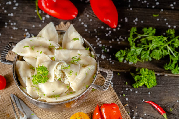 dumplings made of red and white fish meat, in a vintage rustic bowl plate, fork knife spoon, salt, spices, fresh herbs, stand and lie, different angles, on a wooden cutting kitchen table, dark light albóndigas hechas de carne de pescado rojo y blanco, en un plato de cuenco rústico vintage, cuchara de cuchillo de tenedor, sal, especias, hierbas frescas, soporte y mentira, diferentes ángulos, en una mesa de cocina de corte de madera, luz oscura