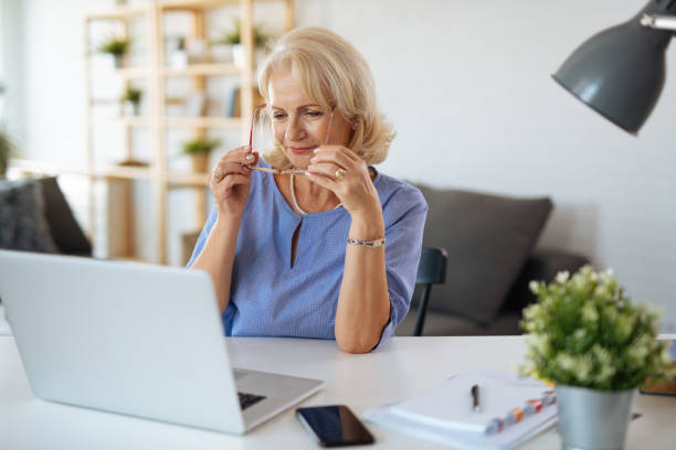 istock Senior woman using laptop at home 1181172630