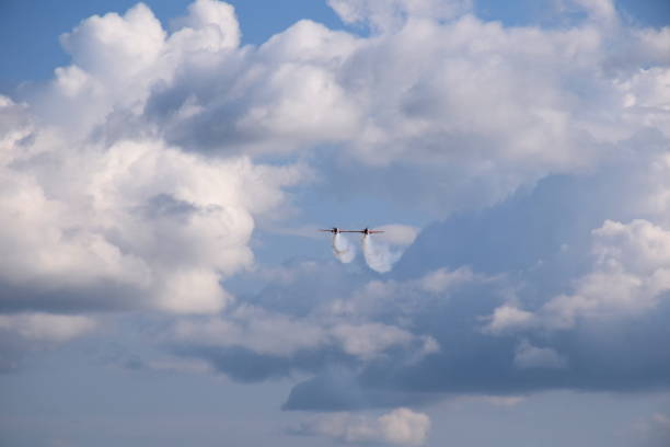 istock Two red and white passenger planes flying towards the camera dynamically and generating some smoke or fog seen on a Polish countryside during a cloudy yet warm summer day 1181177910