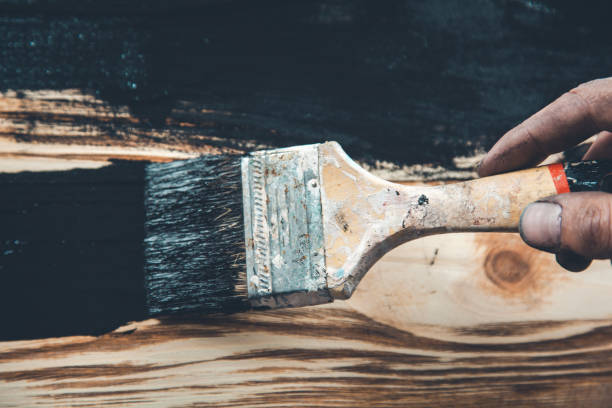istock man hand black paint and brush on wood 1181180169