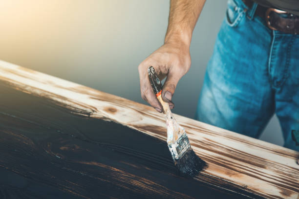 istock man hand black paint and brush on wood 1181180210