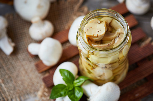 Marinated pickled champignon mushrooms (Agaricus bisporus) in jar