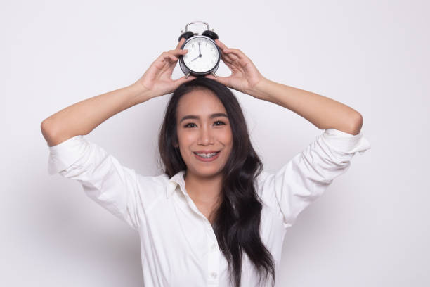 istock Young Asian woman smile with a clock. 1181187702