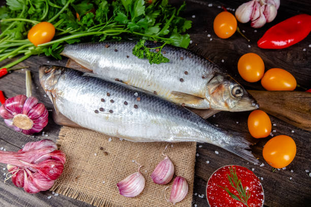 istock fresh red whole fish, lies on ice, headless, with green basil, light 1181192723