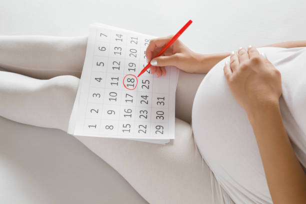 jonge zwangere vrouw markering geboortedag in kalender. baby verwacht concept. planning van de toekomst. close-up. - pregnant count stockfoto's en -beelden