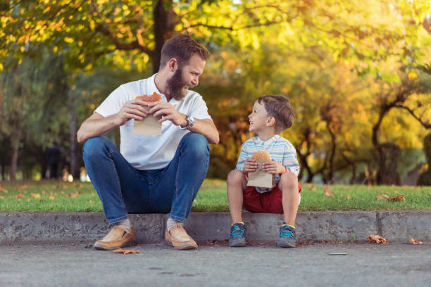 istock Father and son eating burgers 1181195693