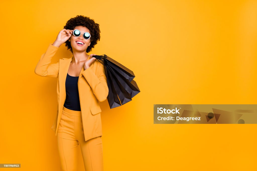 Ritratto di signora allegra positiva divertirsi sul tempo libero le specifiche touch godono di 50 off sales bargain feel contenuti che ha fatto acquisti vestiti in stile pantaloni pantaloni sfondo giallo isolato - Foto stock royalty-free di Fare spese