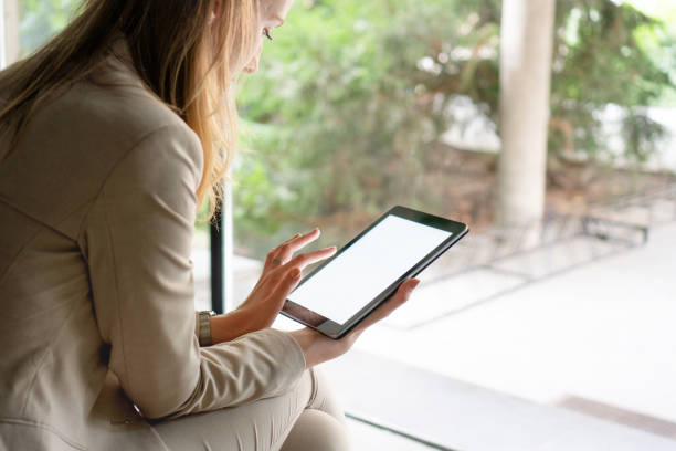 istock Young woman typing on digital tablet 1181197216