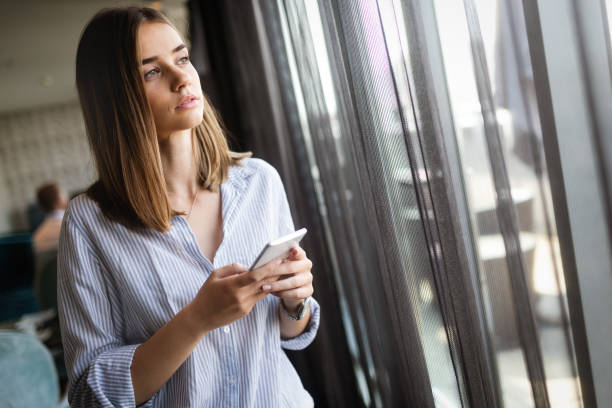 istock Concentrated woman thinking with phone in hands 1181197709