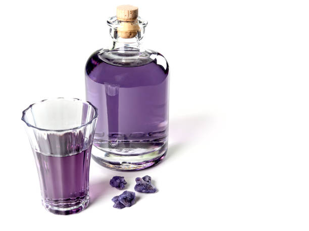 Glass bottles filled with food colouring on a white background showing reflections and patterns