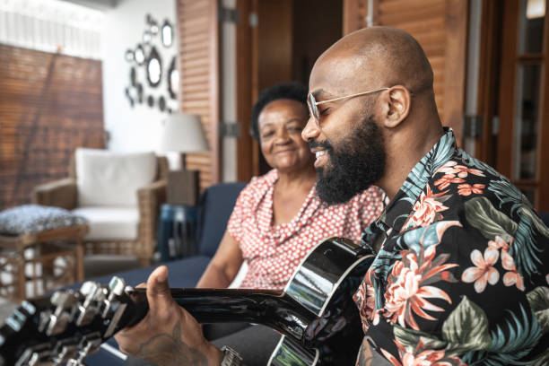 Happy man playing guitar to his mother