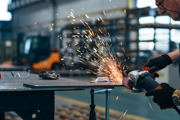 istock Factory worker cutting metal, sparks flying, close-up. 1181207937