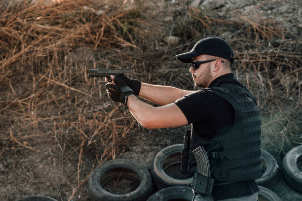 istock Side view of a private security contractor shooting a hand gun. 1181208049