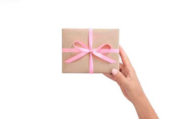 Female hands holding present box or gift box package in craft paper