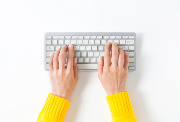 Typing on keyboard Top view on female elegant hands on a computer keyboard. Isolated white background and clipping path. Simple design, large copy space for your designs enter key photos stock pictures, royalty-free photos & images