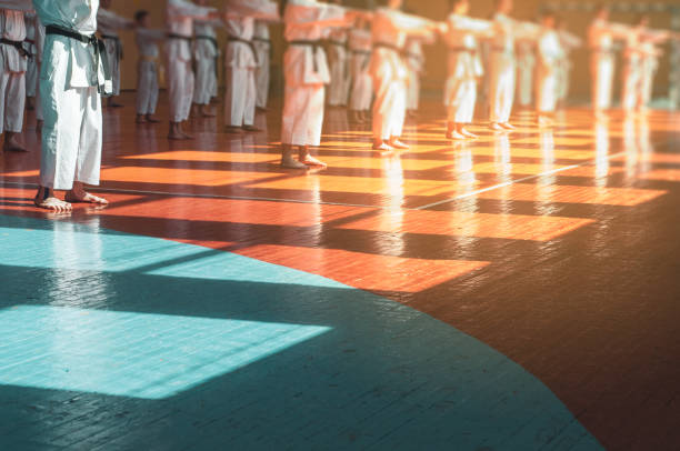 Kids training on karate-do. Young athletes in traditionally white kimonos with colored belts. Banner with space for text. Retro style.