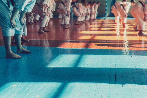 istock Kids training on karate-do. Young athletes in traditionally white kimonos with colored belts. Banner with space for text. Retro style. 1181209462