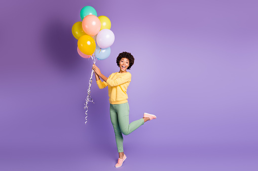 Full length photo of funny funky girl hold many balloons get gift on her birthday, feel astonished expression scream wow omg wear casual style clothing isolated violet purple color background