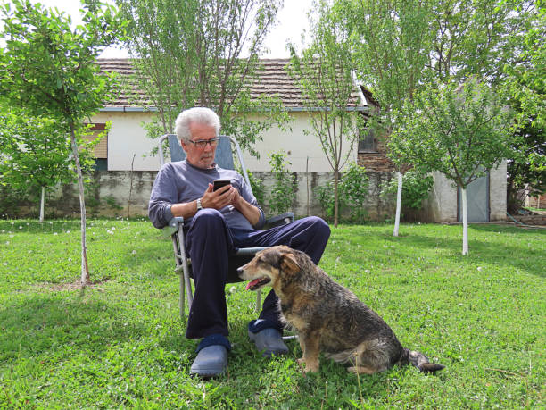 istock Senior Man with Mobile Phone in the Backyard 1181210901