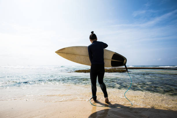istock Woman surfer with surfboard going to surf 1181211341