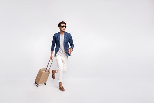 Full length body size view of nice attractive stylish business tourist wearing, blue checked blazer modern look carrying bag running to registration service isolated over light white pastel background