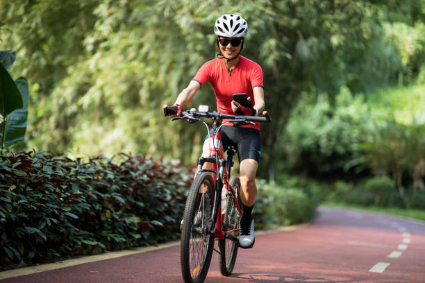 Riding on bike path,using smartphone while riding bike on sunny day