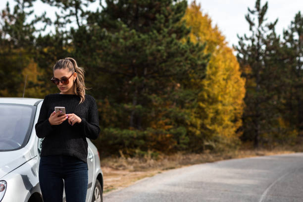 istock Lady on the road looking GPS 1181214163