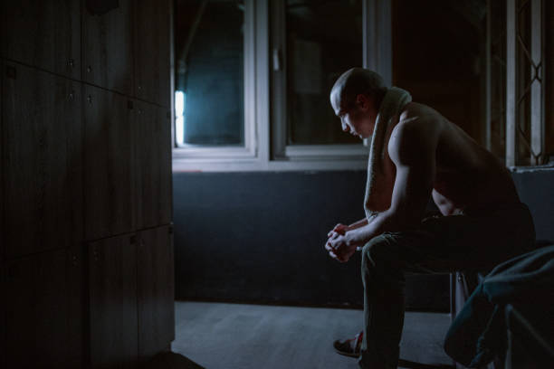 istock Body builder sitting in dark locker room 1181216050