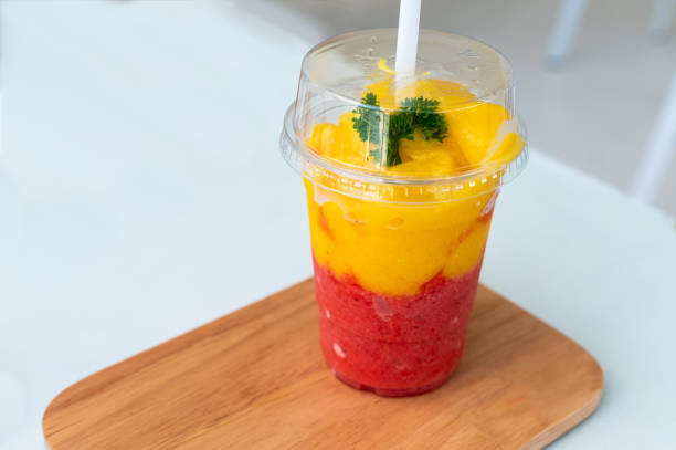 istock Mango strawberry slushy on wooden plate with white background 1181219345