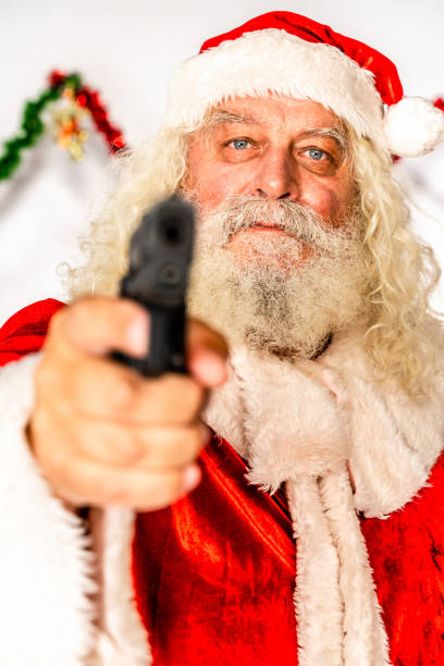 istock Santa Claus looking at camera with gun in his hands 1181219841