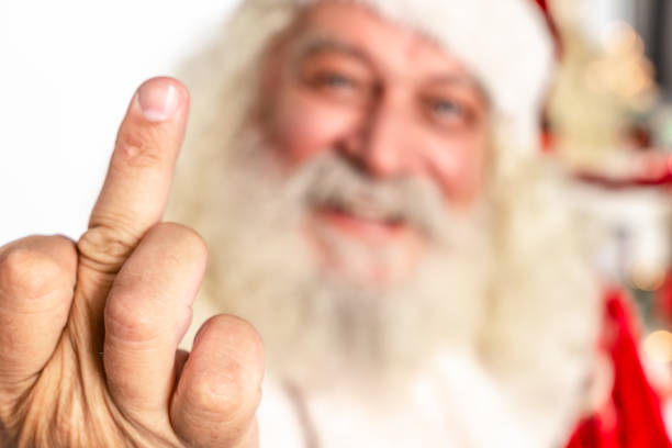 rude jultomten ger långfingret underteckna närbild - santa hat bildbanksfoton och bilder