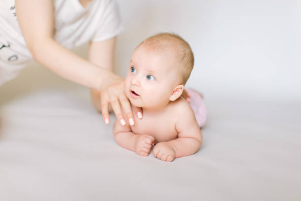 istock little baby massage back, isolated on white. 1181221407