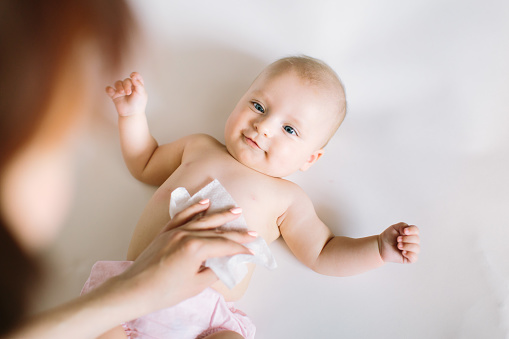 Hygiene - young momy wiping the baby skin with wet wipes. Cleaning wipe, pure, clean.