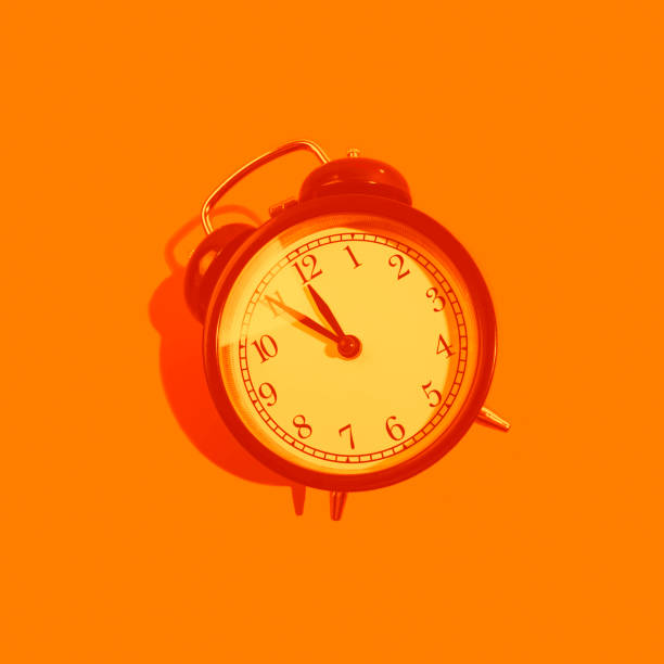 istock Monochrome orange classic style alarm clock isolated on background 1181222196