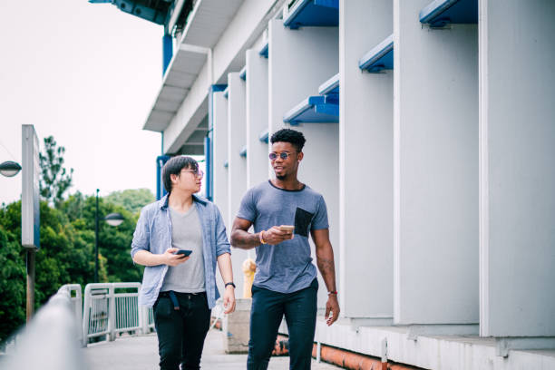 istock Two Stylish Business Person Walking While Using Smartphone 1181224369
