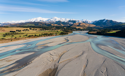The view from a helicopter of the Waimakariri River and the farmlands of the Canterbury Plain, on New Zealand's South Island, stretching away towards the mighty Southern Alps.