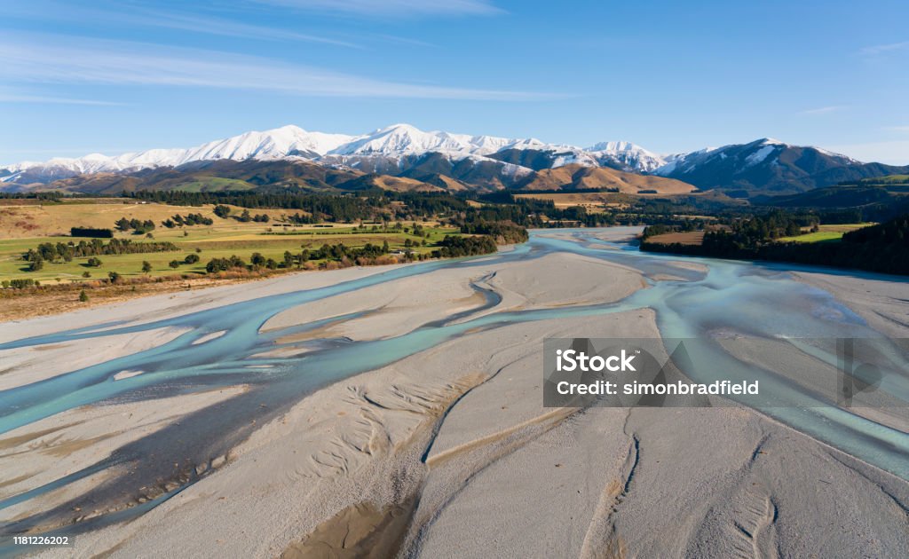 Canterbury Plain And The Southern Alps The view from a helicopter of the Waimakariri River and the farmlands of the Canterbury Plain, on New Zealand's South Island, stretching away towards the mighty Southern Alps. New Zealand Stock Photo